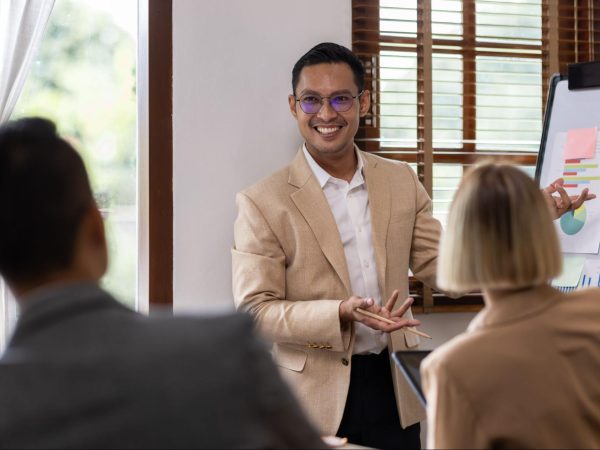 An Asian business consultant using graphs to explain the plan to executives.